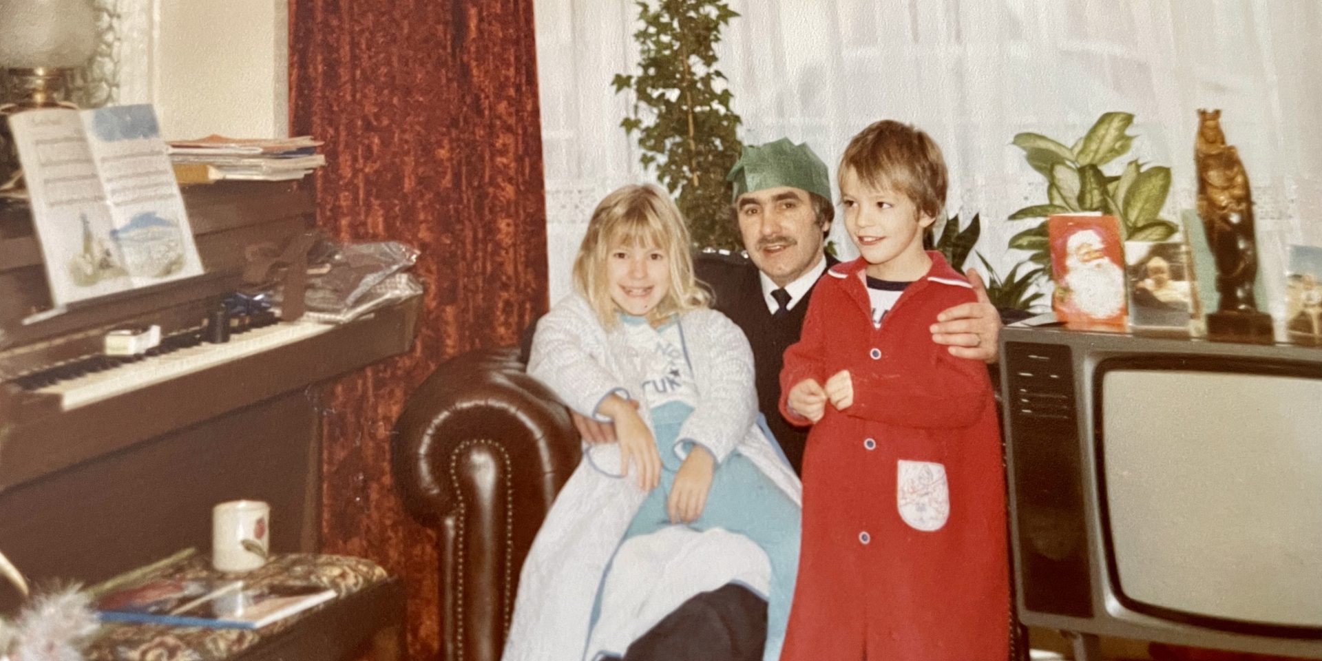 A photograph depicting Mel, her dad, and brother taken at Christmas in 1984