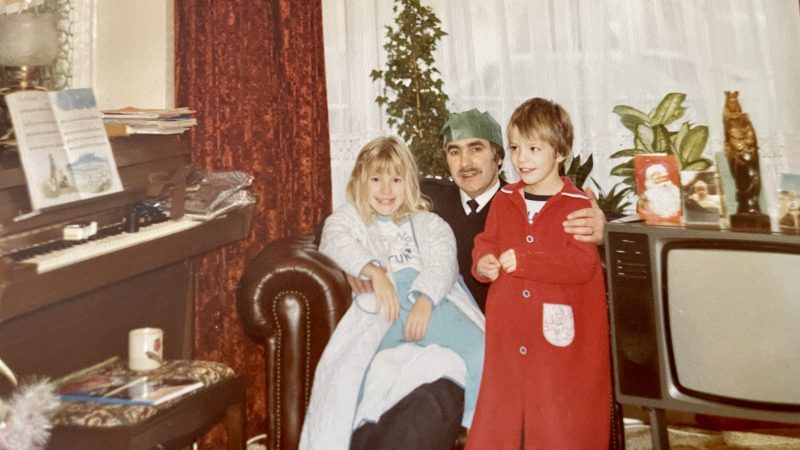A photograph depicting Mel, her dad, and brother taken at Christmas in 1984